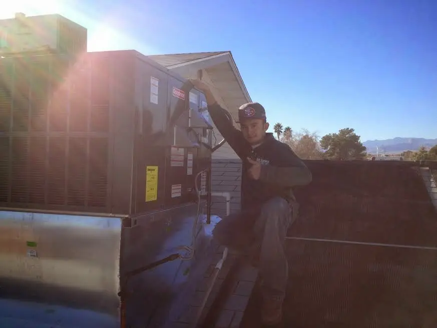 HVAC technician performing HVAC Inspection on a rooftop unit in Fairmont